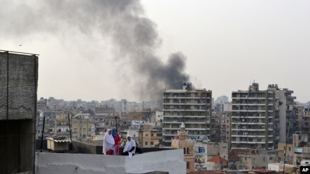 Smoke from burning tires rises over the Tripoli, Lebanon, skyline as people protest the killing Friday in Beirut of the country's intelligence chief, Brig. Gen. Wissam al-Hassan and at least seven others, October 20, 2012. 