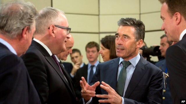 NATO Secretary General Anders Fogh Rasmussen, center right, speaks with, from left, Luxembourg's Foreign Minister Jean Asselborn, Dutch Foreign Minister Frans Timmermans and Norwegian Foreign Minister Borge Brende, April 1, 2014.