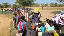 In this photo taken Wednesday, Dec. 18, 2013 and released by the United Nations Mission in South Sudan (UNMISS), civilians fleeing violence seek refuge at the UNMISS compound in Bor, capital of Jonglei state, in South Sudan.