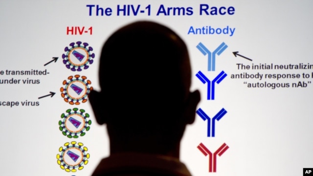 A member of the audience looks at slides during a speech given by leading AIDS vaccine official in Washington, July 25, 2012.