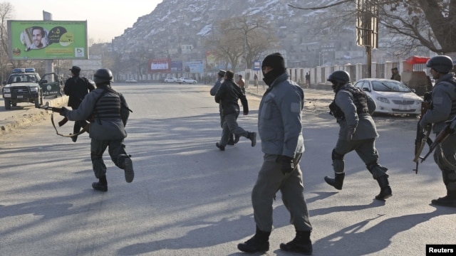 Afghan police officers run to the Kabul traffic police headquarters as it is attacked by insurgents in Kabul, January 21, 2013. 