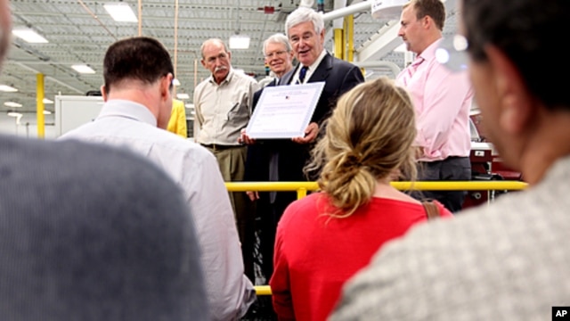 Republican presidential hopeful, former House Speaker Newt Gingrich, center, prepares to sign the Strong America Now pledge, while touring C&M Machine Products in Hudson, New Hampshire, June 8, 2011.