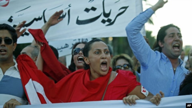 People chant slogans during a demonstration held after a group of individuals attacked the CinemAfricArt building to protest a controversial film called 'No God, No Master,' in Tunis, July 7, 2011