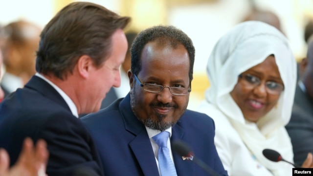 Britain's Prime Minister David Cameron (L) and Somali President Hassan Sheikh Mohamud (C) shake hands after making their opening speeches the Somalia conference in London May 7, 2013.