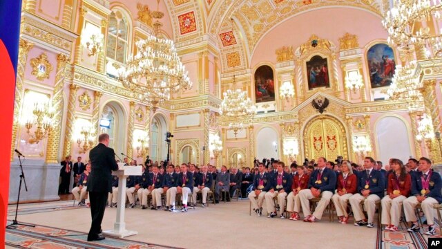 FILE - In this file photo taken on Tuesday, Sept. 11, 2012, President Vladimir Putin, foreground left, speaks as he meets with the national paralympic team after they returned from the Paralympic Games 2012 in London, in Moscow's Kremlin, Russia. The entire Russia team has been banned from competing in the Paralympic Games in September as punishment for the country's systematic doping program.