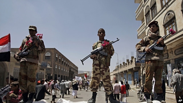 Defected soldiers stand guard next to the site of a demonstration by protestors to demand the resignation of Yemen's President Ali Abdullah Saleh in Sanaa, Yemen, Thursday, Oct. 6, 2011.