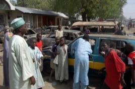 Residents survey vehicles damaged after a bomb blast at a primary school in Maiduguri, the capital of Nigeria's Borno state, February 29, 2012.