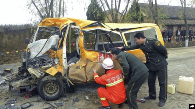 Rescuers inspect a school bus after it collided with a truck [not seen] in Yulinzi township of Zhengning county, Gansu province, November 16, 2011.