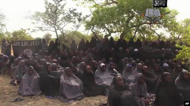 FILE- This image, taken May 12, 2014, from video  by Nigeria's Boko Haram terrorist network, allegedly shows the girls abducted from Chibok.