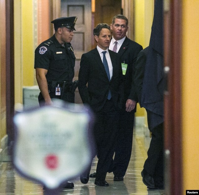 U.S. Treasury Secretary Timothy Geithner (C) walks through a U.S. Capitol hallway before meeting with Senate Minority Leader Mitch McConnell (R-KY) in Washington, D.C., November 29, 2012.