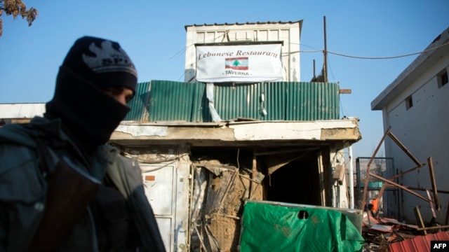 Cảnh sát Afghanistan đứng gác bên ngoài lối vào của nhà hàng bị tấn công ở Kabul, 18/1/2014