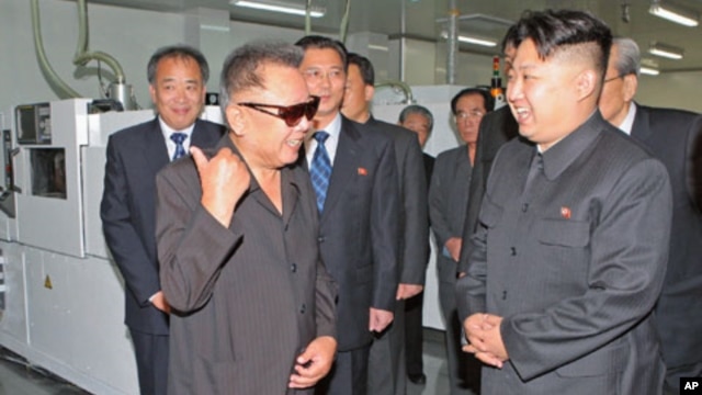 North Korean leader Kim Jong Il (front L) and his son Kim Jong-un (R) talk as they visit Mokran Video Company in Pyongyang, in this undated picture released September 11, 2011.
