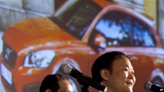 Li Shufu, right, chairman of Chinese automaker Geely, speaks while a photo of a Volvo car is projected on a screen during a press conference in Beijing, 30 Mar 2010