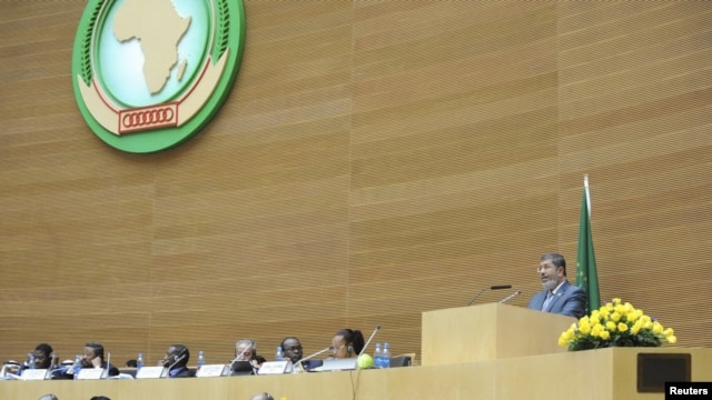 Egypt's President Mohamed Morsi (R) delivers a speech during the opening of the African Union (AU) leaders' meeting in Addis Ababa, July 15, 2012.  