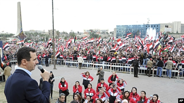 Syria's President Bashar al-Assad addresses his supporters during a surprise appearance at a rally in Umayyad Square in Damascus, January 11, 2012.