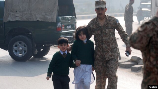 Vojnik ispraća decu iz vojne škole u Pešavaru, koju su napali pripadnici Talibana