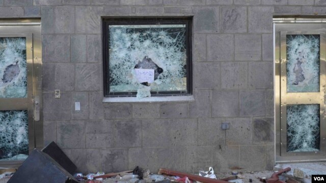 "Anything but the messenger of God," reads a sign left in the shattered window of a U.S. compound after it was stormed by rioters in Sana'a, Yemen, Sept. 13, 2012. (C. Coombs for VOA)