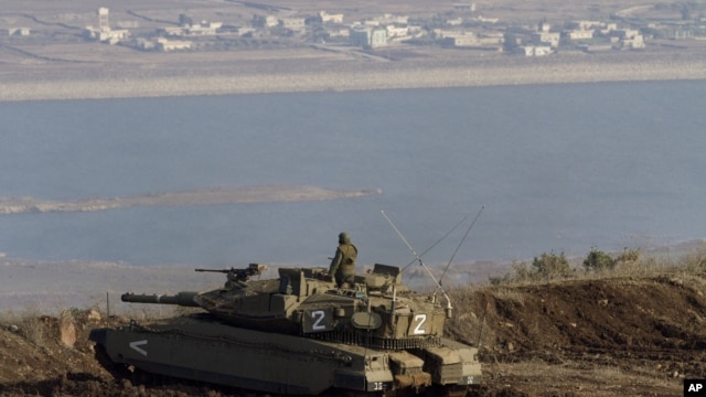 Seorang tentara Israel tengah mengamati desa Bariqa di Suriah, wilayah terdekat dengan perbatasan Israel-Suriah, dekat Alonei Habashan di Dataran Tinggi Golan (Foto: dok). Rusia menyatakan kepriatinannya atas serangan pesawat tempur Israel atas wilayah Suriah, Rabu (30/1).