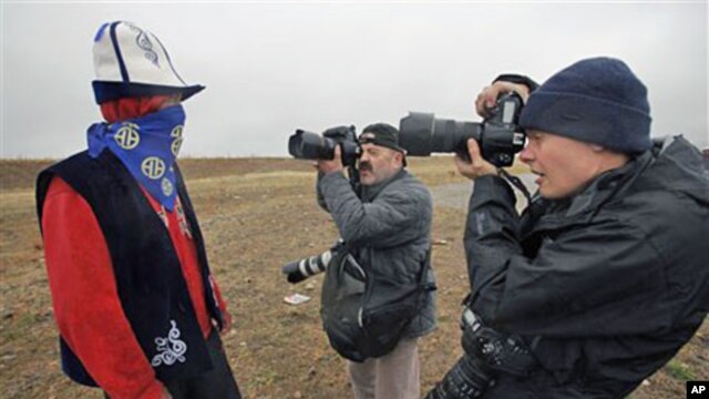 A supporter of former Kyrgyz PM and leader of the Ar-Namys party Felix Kulov poses for photographers during an election campaign rally in Baytik, south of Bishkek, 08 Oct 2010