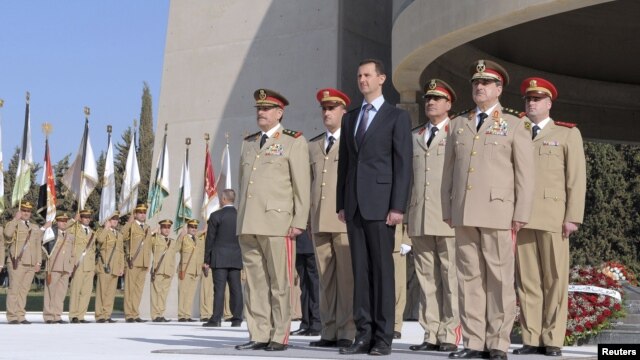 President Bashar al-Assad stands with his military generals, most of whom are Alawites, at the Tomb of the Unknown Soldier in Damascus, October 6, 2011 