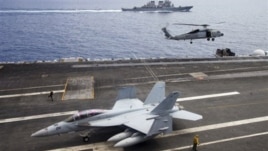 Máy bay chiến đấu F/A-18F Super Hornet và trực thăng SH-60 Seahawk của hải quân Mỹ trên tàu sân bay USS George Washington, phía sau là tàu khu trục USS John S. McCain (DDG-56) ngoài khơi bờ biển Việt Nam, ngày 13/8/2011.