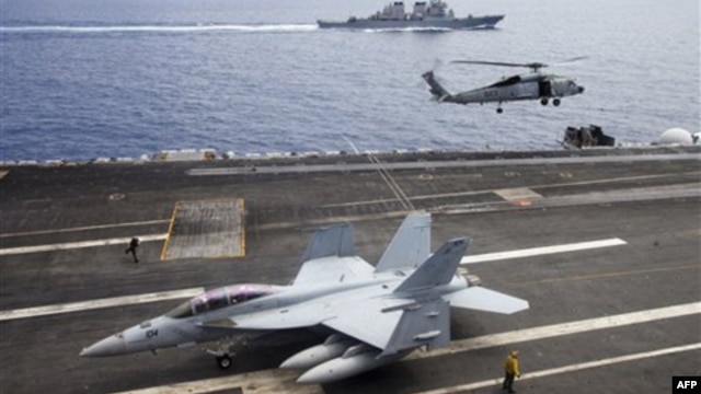 Máy bay chiến đấu F/A-18F Super Hornet và trực thăng SH-60 Seahawk của hải quân Mỹ trên tàu USS George Washington, phía sau là tàu khu trục USS John S. McCain (DDG-56) ngoài khơi bờ biển Việt Nam, tháng 8/2011