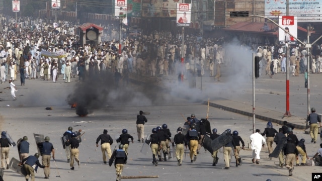 Police chase protesters during an anti-U.S. rally in Peshawar, Pakistan, September 21, 2012. 