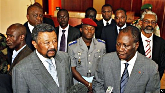 Ivory Coast's internationally-recognized President, Alassane Ouattara, right, stands with African Union Commission Chairman, Jean Ping, left, addressing journalists in Abidjan, March 5, 2011