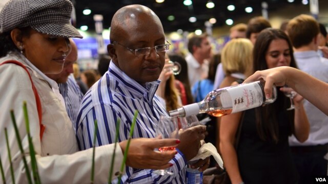 A couple at the WineX Wine Festival in Sandton samples the red wine from Leopard's Leap, a winery on the Western Cape of South Africa, October 2012. (VOA/Peter Cox)                                     