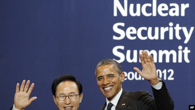 South Korea's President Lee Myung-bak (L) poses with U.S. President Barack Obama as he arrives for a working dinner at the Nuclear Security Summit at the Convention and Exhibition Center in Seoul, March 26, 2012.