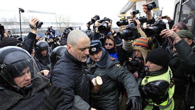 Police officers detain opposition activist Sergei Udaltsov outside the NTV television station in Moscow, Sunday, March, 18, 2012.