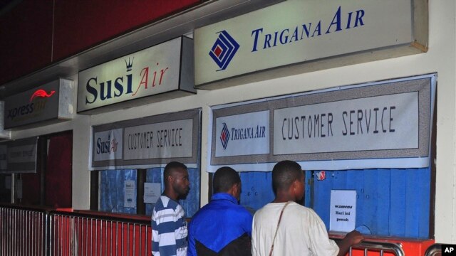 Keluarga penumpang pesawat Trigana Air yang hilang berdiri di depan loket Trigana Air yang tutup di bandara Sentani di Jayapura, Papua (16/8). 