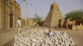 Men work alongside one of Timburktu's historic mud mosques, in Timbuktu, Mali. (file photo)