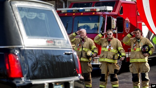 Bomberos saludan el paso del cortejo fúnebre de Daniel Gerard, de 7 años, una de las víctimas de la matanza en Connecticut, cuyo funeral se realizó ayer.