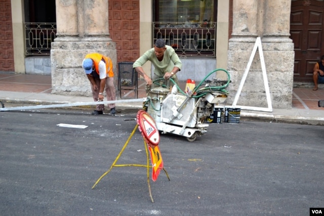 Workers make repairs on a road in Havana.