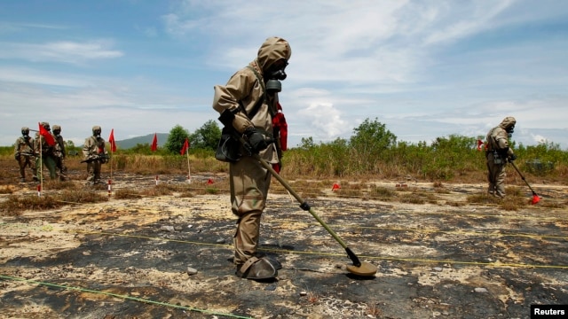 FILE - Soldiers detect Unexploded Ordnance (UXO) and defoliant Agent Orange in Vietnam's central Da Nang City.
