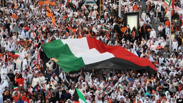 Islamist, nationalist and liberal opposition groups carry a large national flag as they gather to protest the Kuwait government's amendment of the electoral law and support a boycott on the country's election on November 30, 2012 in Kuwait City. 