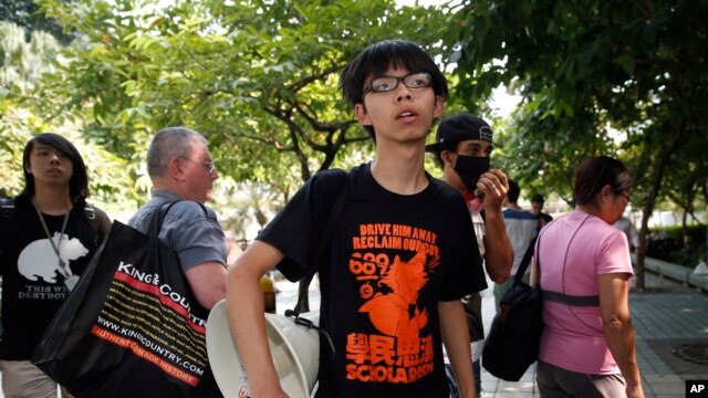 Lãnh tụ sinh viên Joshua Wong đứng nhìn cảnh sát dỡ bỏ các rào chắn. Một sinh viên biểu tình cho biết không có lựa chọn nào khác hơn là tuân lệnh của cảnh sát.