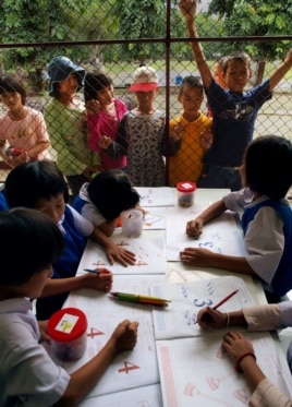 Stateless children in Thailand peer into the classroom of a school they are barred from attending. (Joseph Quinnell)