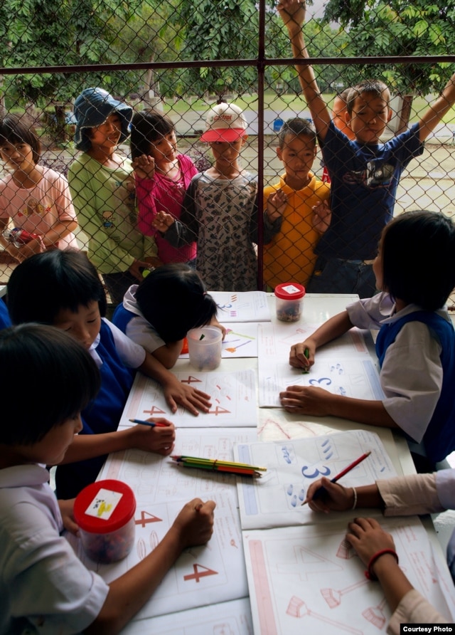 Stateless children in Thailand peer into the classroom of a school they are barred from attending. (Joseph Quinnell)