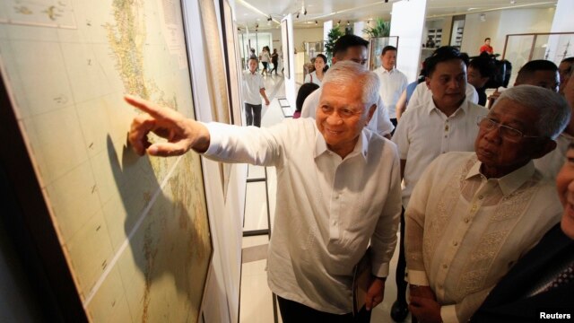 Ngoại trưởng Philippines Albert Del Rosario chỉ vào một bản đồ cổ bên cạnh Bộ trưởng Quốc phòng Voltaire Gazmin tại trường đại học Công giáo ở Manila.