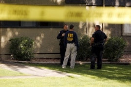 An investigator talks to police officers at the Autumn Ridge apartment complex which had been searched by investigators in Phoenix, Arizona, May 4, 2015.