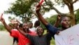 Roman Catholic priest Frank Bwalya (in red) and supporters hold red cards to display their displeasure with the government as they attend a rally in front of the National Assembly, in Lusaka, Zambia, March 22, 2011.