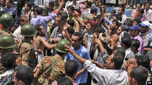 Yemeni army soldiers block the way as anti-government protestors attend a demonstration demanding the resignation of Yemeni President Ali Abdullah Saleh, in Taiz, Yemen, April 10, 2011