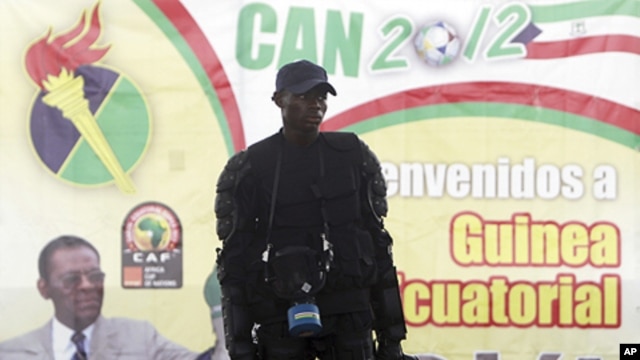 A member of Equatorial Guinea's police special forces stands in front of a banner of President Teodoro Obiang Nguema Mbasogo outside Estadio de Bata "Bata Stadium", which will host the opening match and ceremony for the African Nations Cup, in Bata Januar