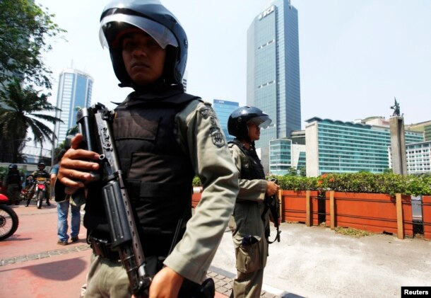 Polisi anti-teror memegang senjata, berjaga-jaga di sebuah distrik bisnis di Jakarta.