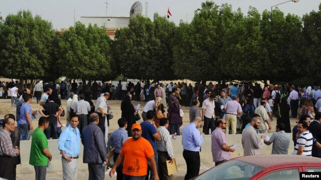 Egyptian nationals living in Kuwait stand in line at the entrance of the Egyptian Embassy before voting in Egypt's presidential elections, in Bnaid al-Gar, Kuwait, May 16, 2012.
