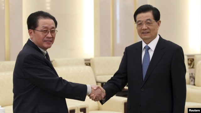 China's President Hu Jintao (R) shakes hands with Jang Song Thaek, Chief of the Central Administrative Department of the Workers' Party of Korea, in Beijing, August 17, 2012.