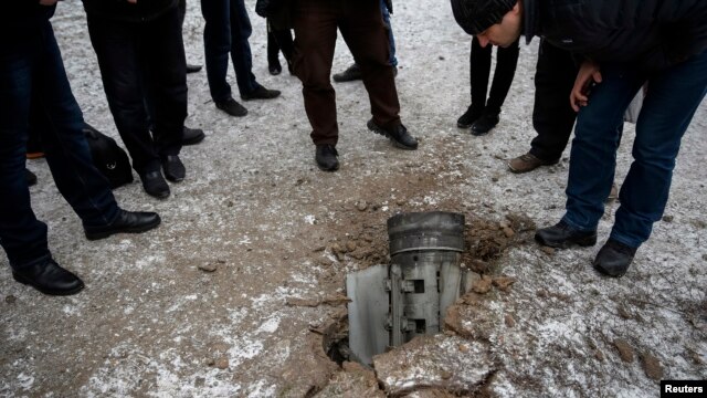 Dân chúng nhìn vỏ rocket nằm trên đường trong thị trấn Kramatorsk, miền đông Ukraine, 10/2/15