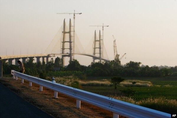 FILE - Work continues on Cambodia longest bridge before it is inauguration in Neak Loeung, southeast of Phnom Penh, Cambodia, Jan. 14, 2015.